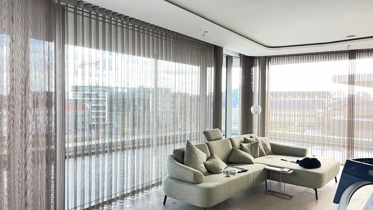 Doorschijnende verticale lamellen rondom een woonkamer met panoramaramen - Sin-tex gordijnen en raamdecoratie, Heusden-Zolder