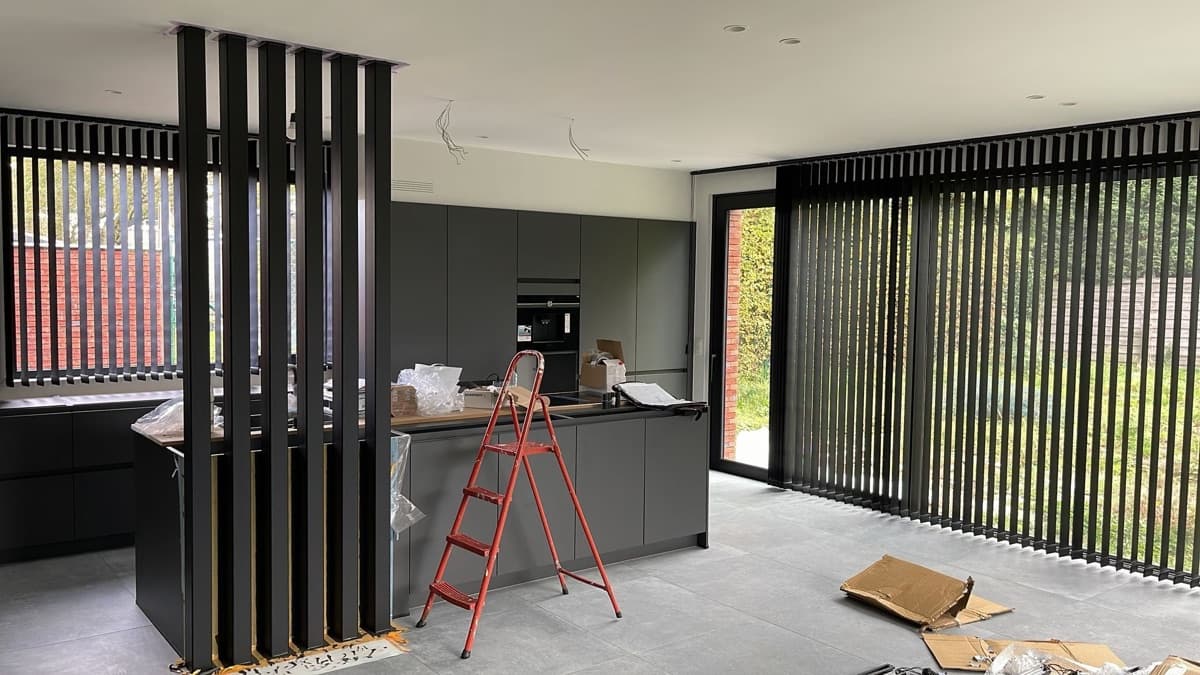Zwarte verticale lamellen in een keuken, tijdens de plaatsing - Sin-tex gordijnen en raamdecoratie, Heusden-Zolder