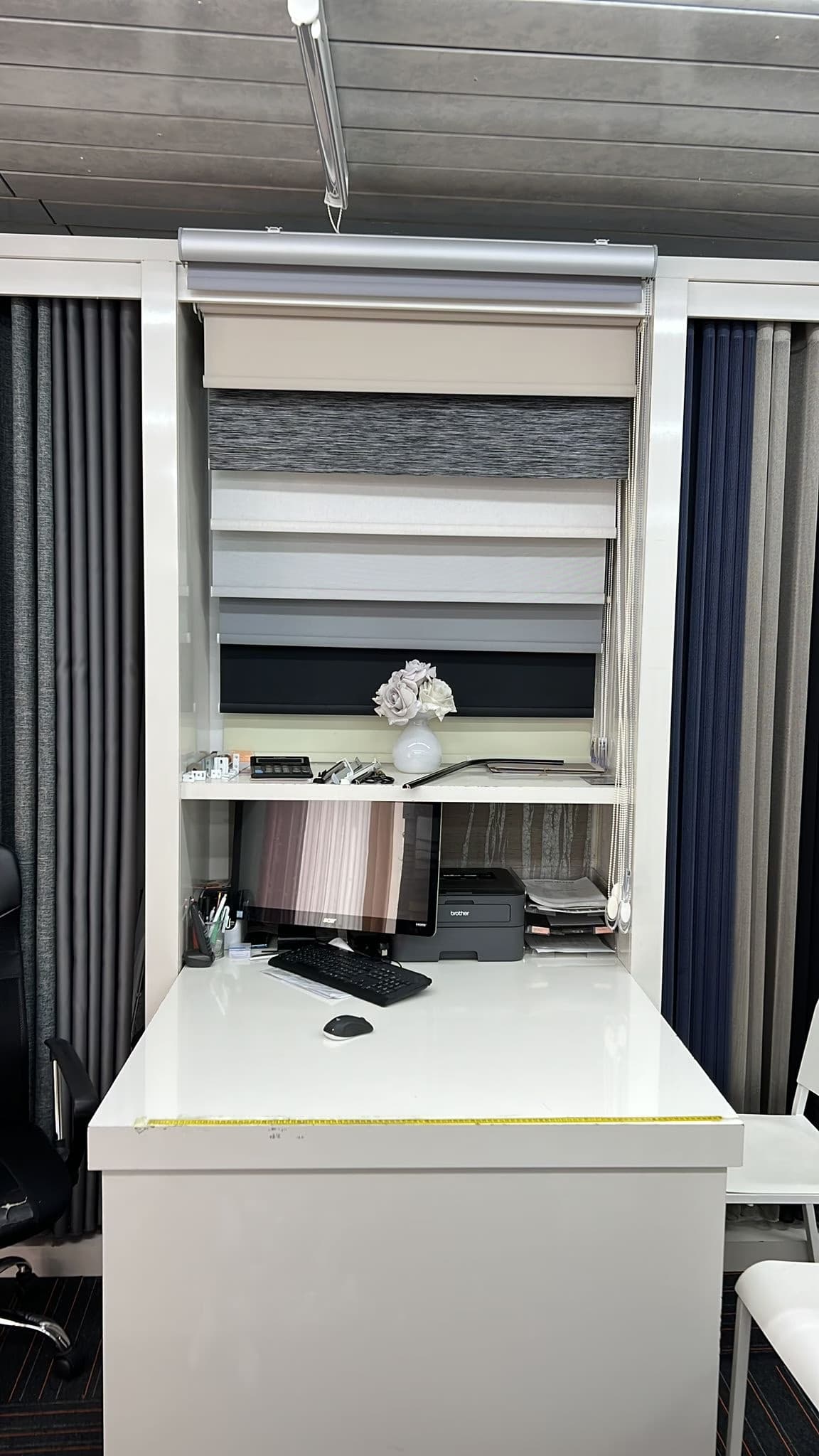 Toonbank met stalen van rolgordijnen in de showroom van Sin-tex - Sin-tex gordijnen en raamdecoratie, Heusden-Zolder