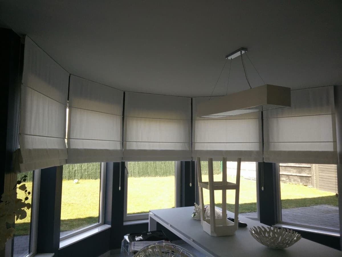 Witte vouwgordijnen in een erker met zicht op de tuin - Sin-tex gordijnen en raamdecoratie, Heusden-Zolder
