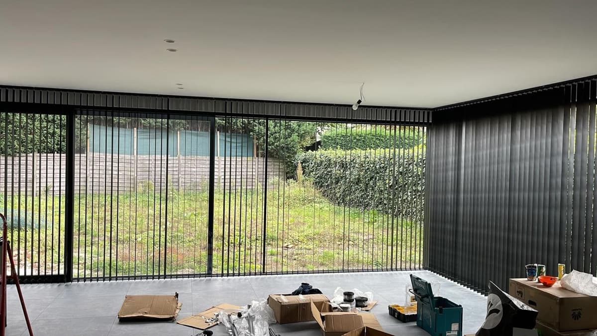 Zwarte verticale lamellen langs een volledige raamwand - Sin-tex gordijnen en raamdecoratie, Heusden-Zolder