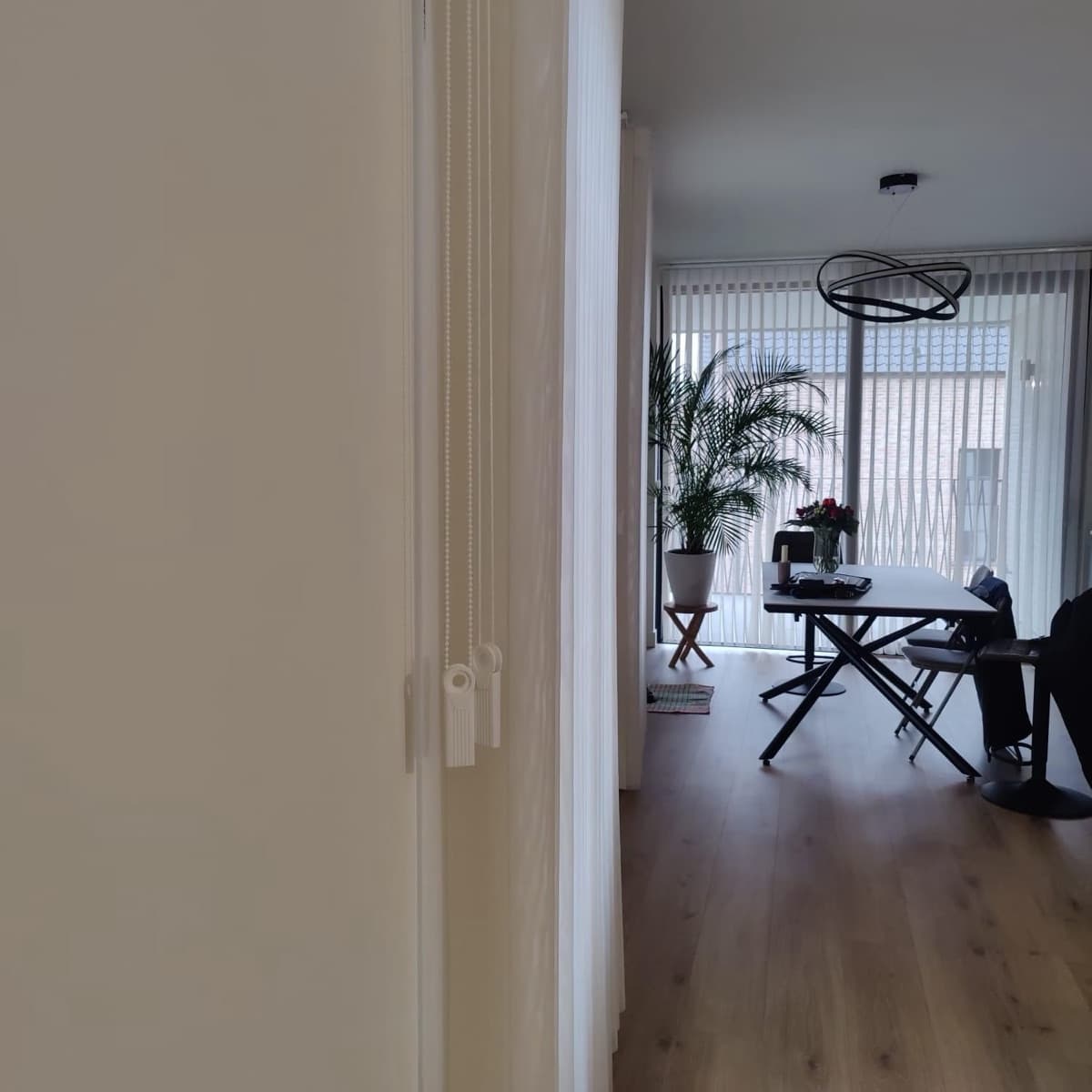 Verticale lamellen opzij geschoven bij de doorgang naar de eetkamer - Sin-tex gordijnen en raamdecoratie, Heusden-Zolder
