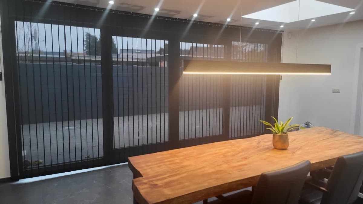 Donkere lamellen op maat voor een brede raampartij in de eetkamer - Sin-tex gordijnen en raamdecoratie, Heusden-Zolder